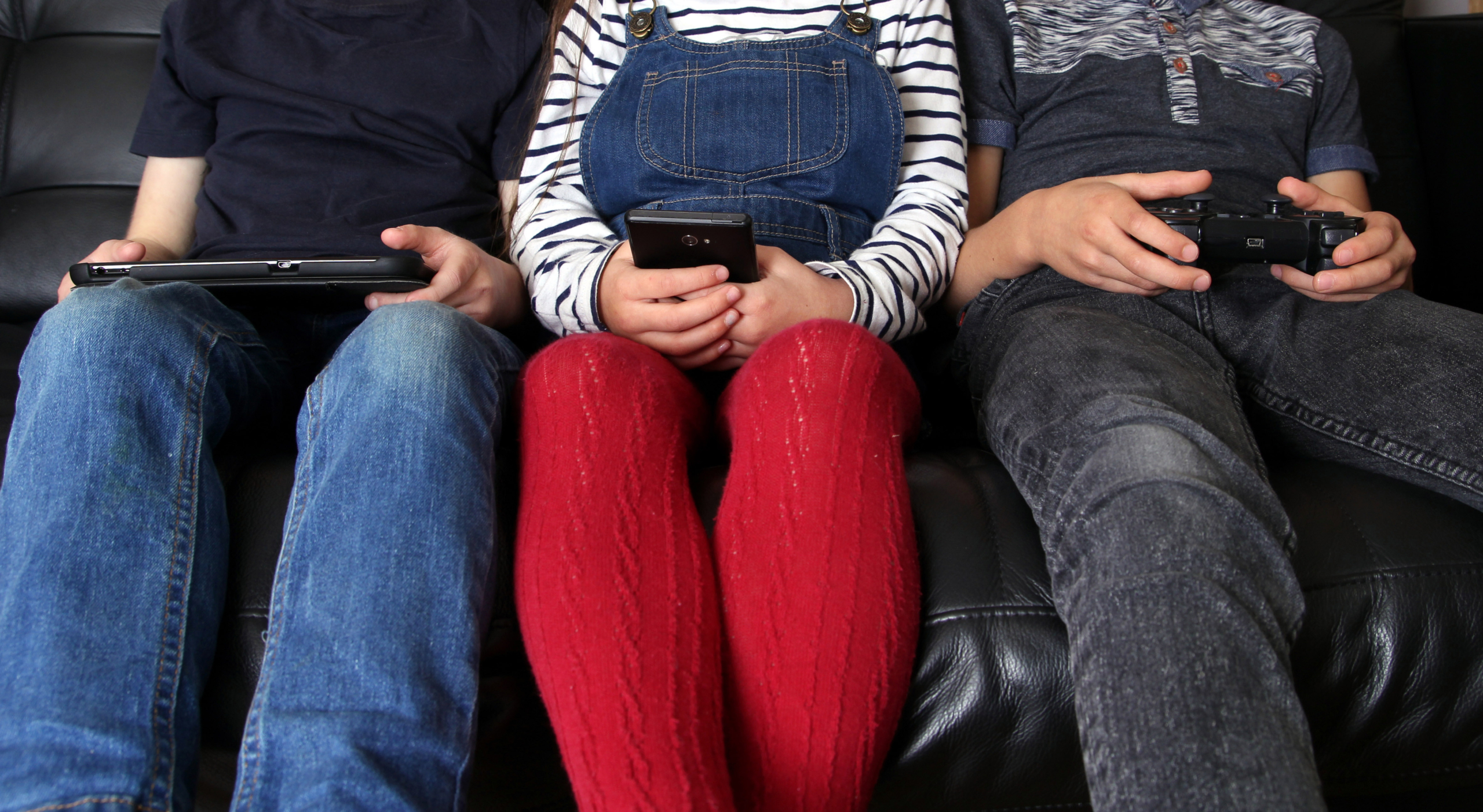 three children on electronic devices